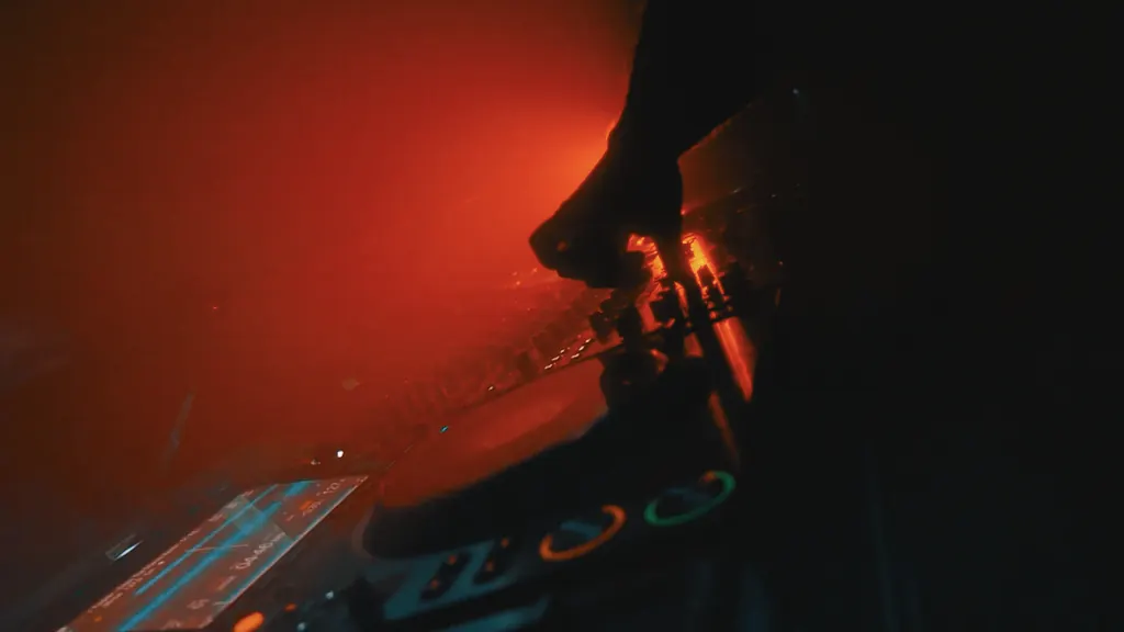 Close-up van DJ-handen op de mixer in rood licht