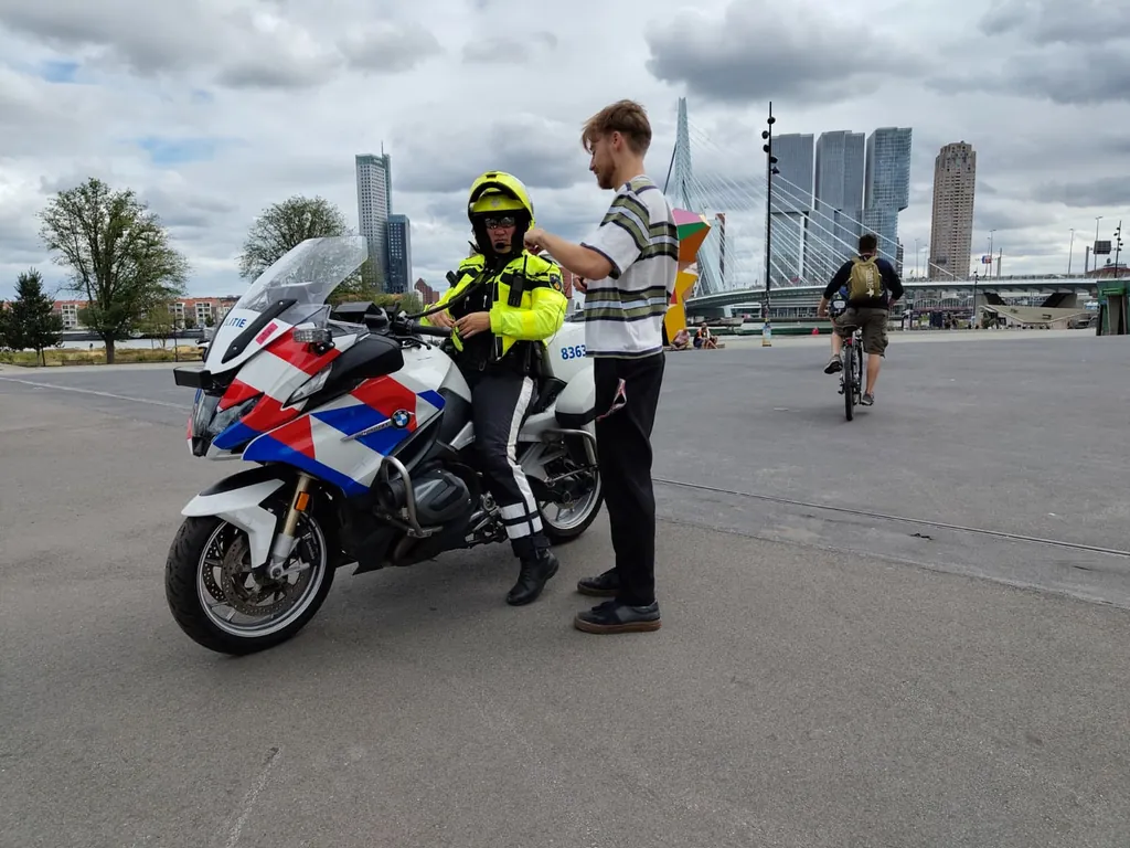 Videograaf filmt een motoragent met de skyline van Rotterdam op de achtergrond